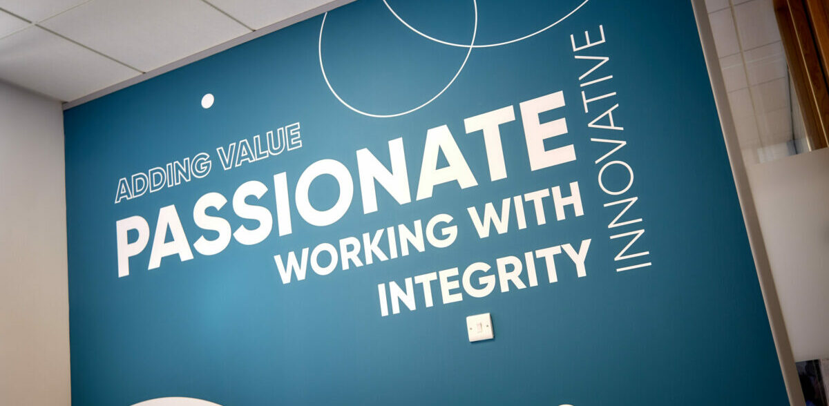 A wall in the Community Ventures office, which says 'Passionate' and 'Working with integrity'